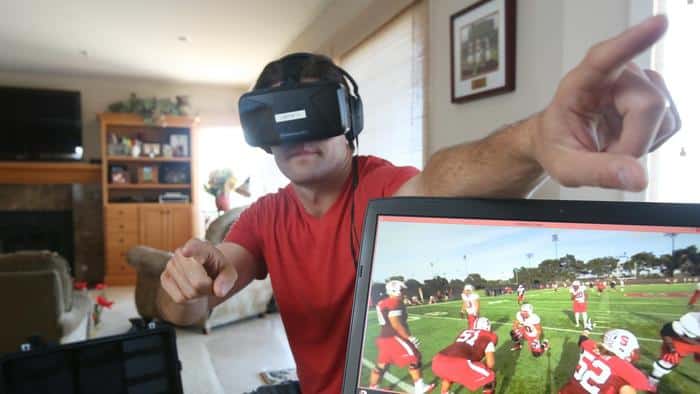 Derek Belch simulates how he can direct players on the field during a demonstration of a VR training simulator